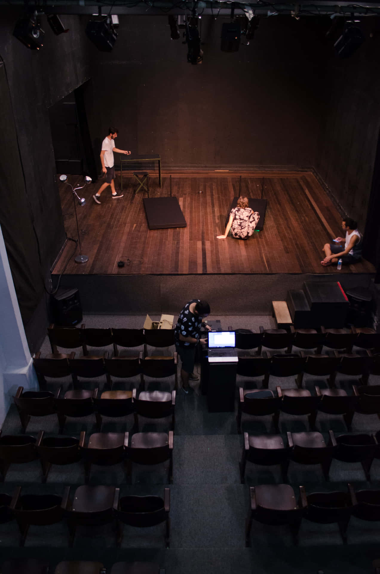 Un grup de actori și actrițe diverse repetând pe scenă Fundal