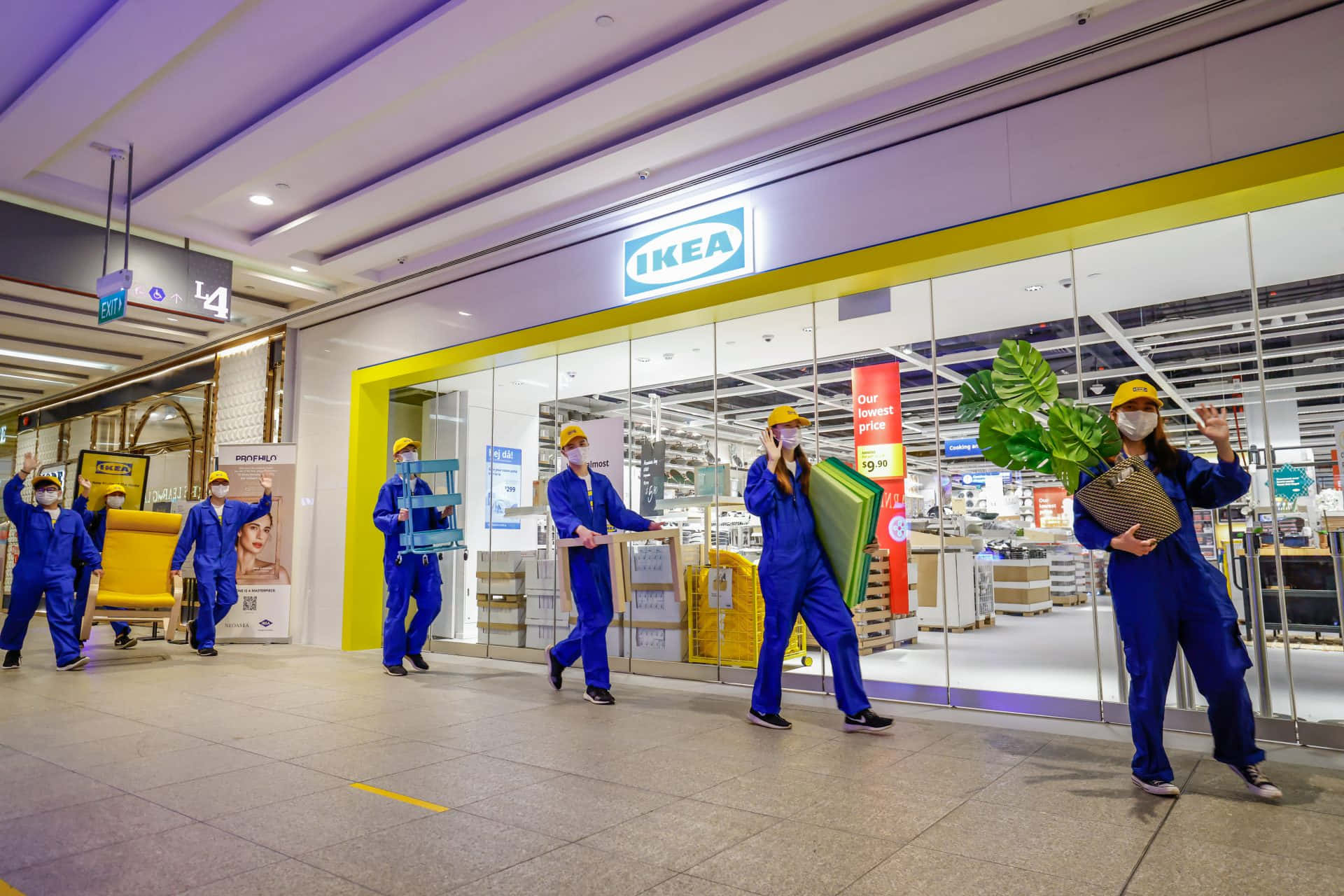 un grup de muncitori care traversează un centru comercial Fundal