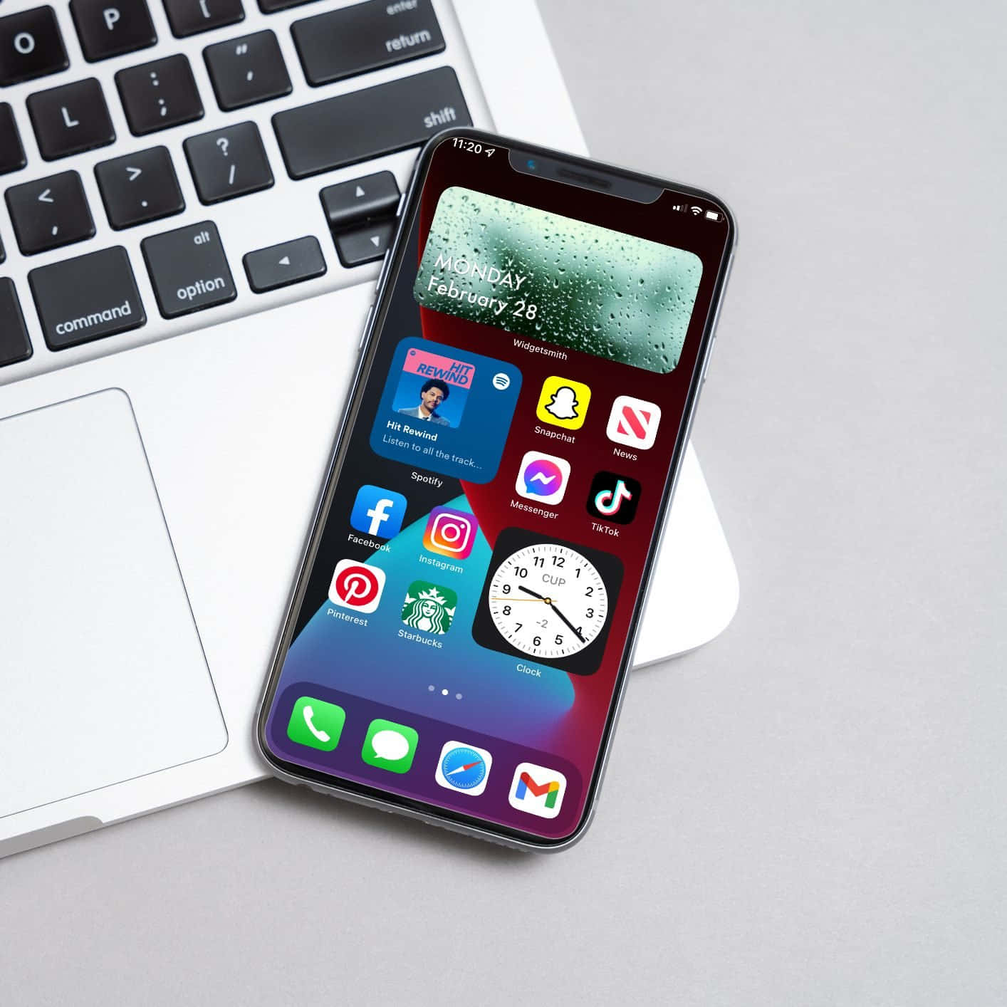 un iPhone XR cu aplicații, așezat lângă un laptop Fundal
