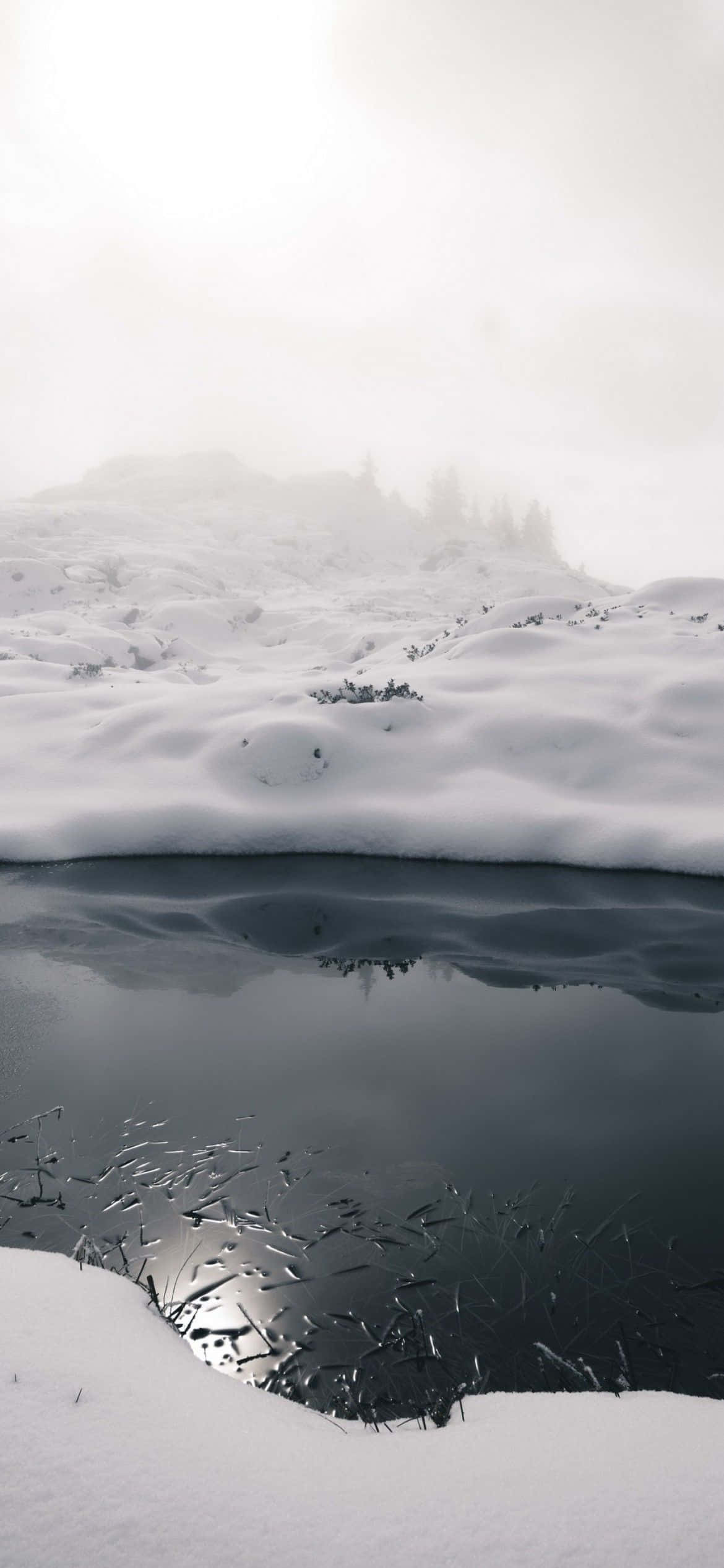 un lac acoperit de zăpadă cu reflexie Fundal