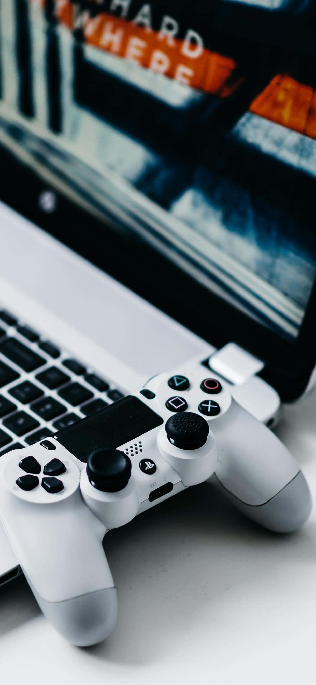 un laptop cu un controller de joc pe el Fundal