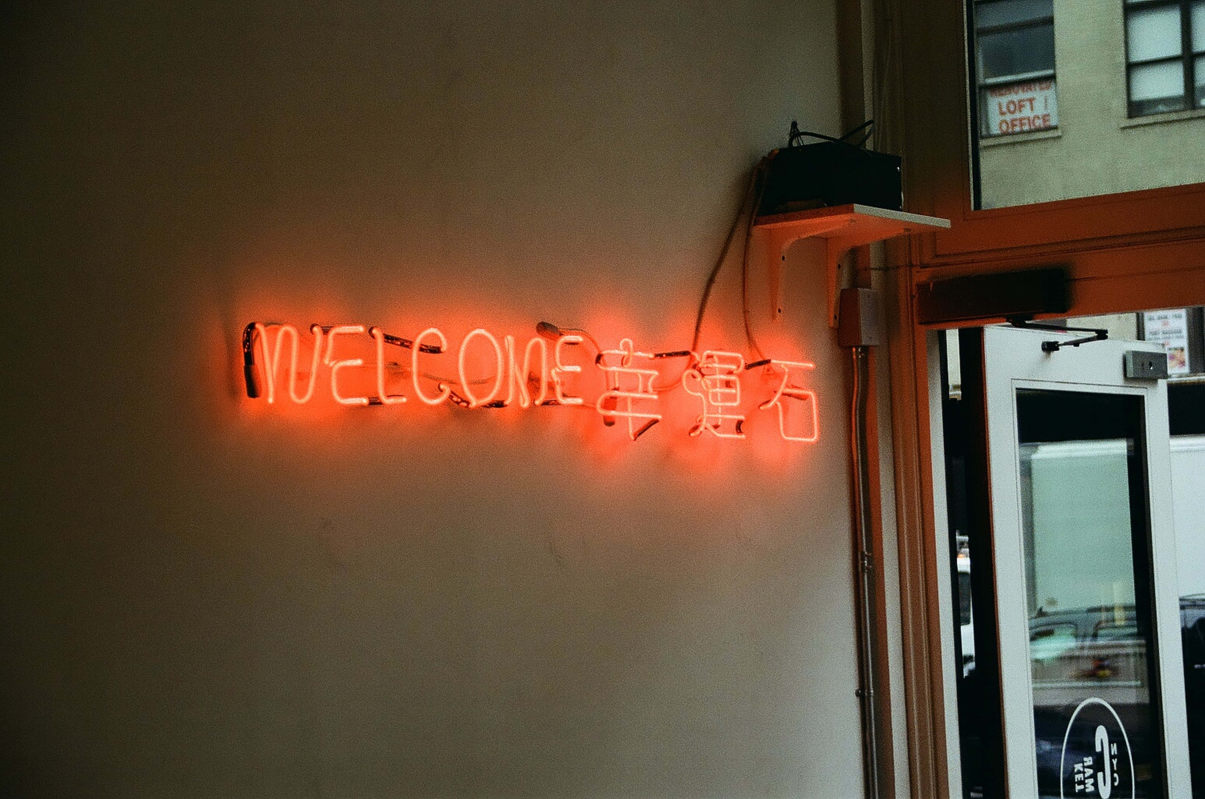 un semn neon care scrie bine ați venit pe un perete Fundal