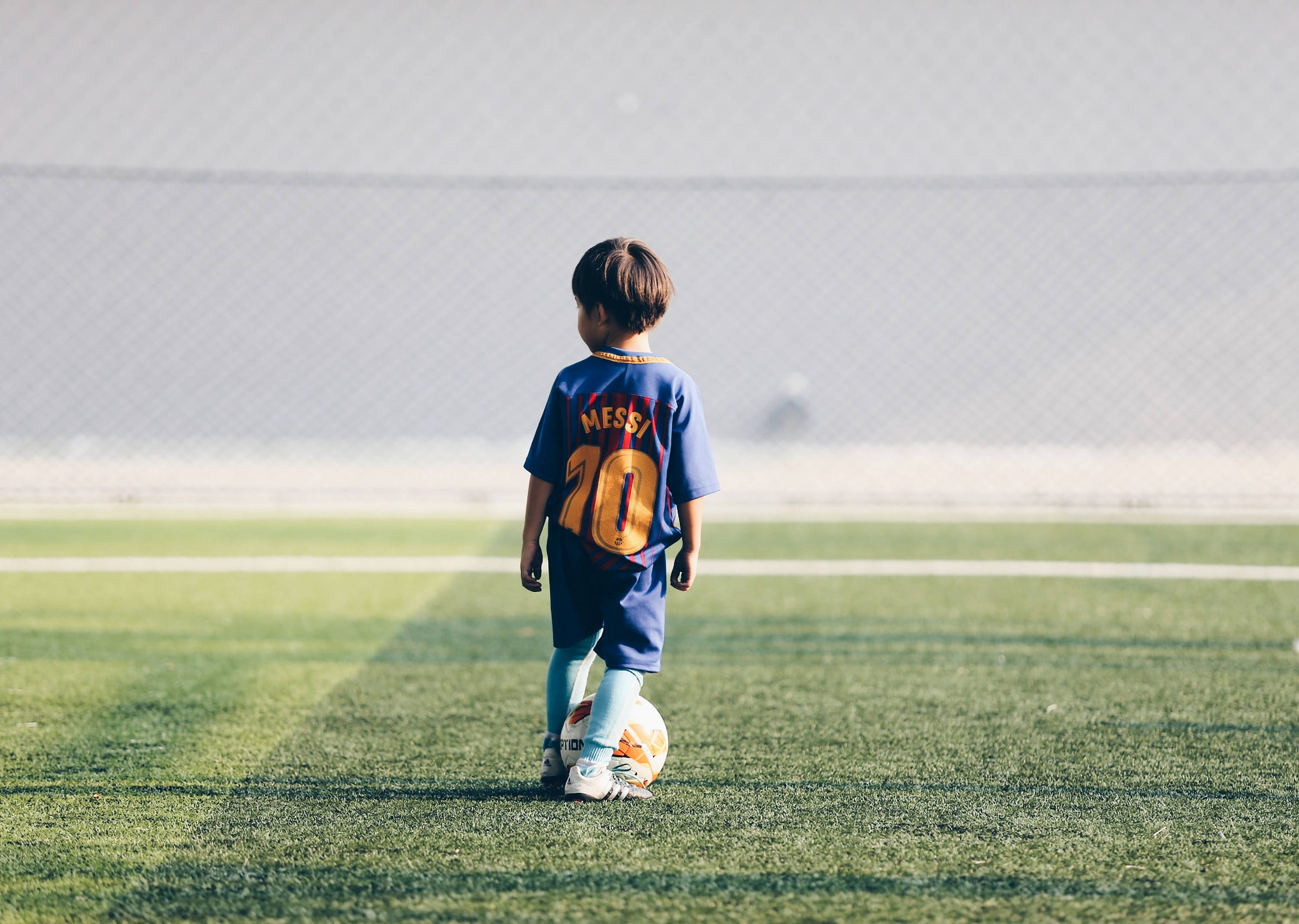 Un tânăr plin de speranță așteaptă cu nerăbdare să poarte într-o zi tricoul lui Lionel Messi. Fundal