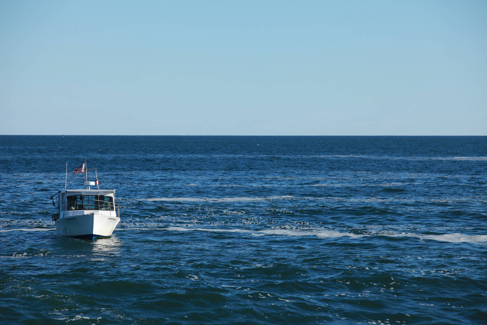 Barcă într-un ocean mare albastru cu valuri pe vreme senină. — Ocean Fundal