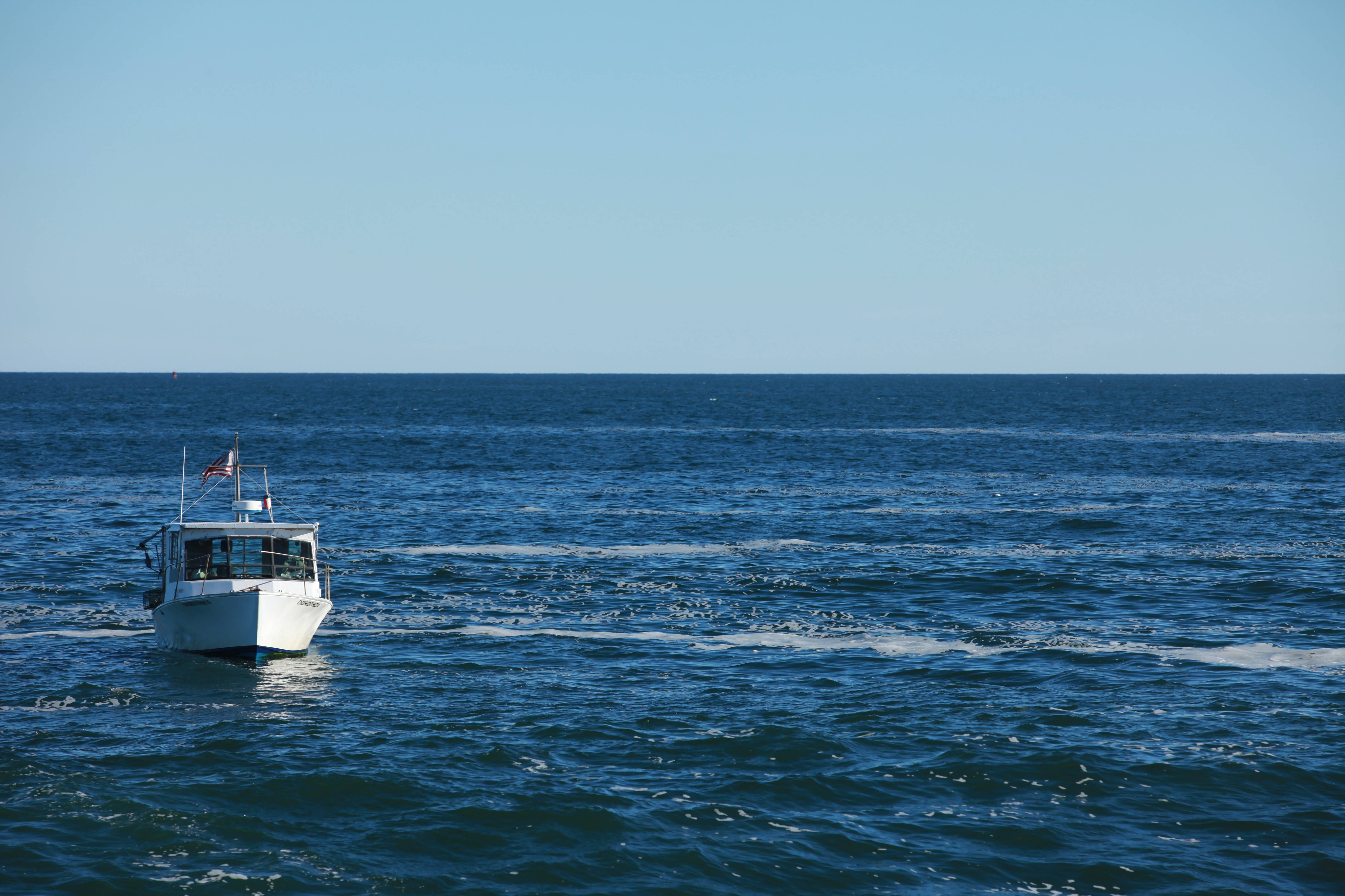 Vastul ocean și o barcă cu pânze, una lângă alta Fundal