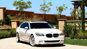 Tapet cu mașina BMW 7 F01 albă cu tuning Asanti la poartă
