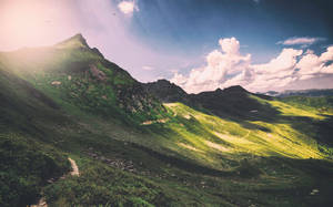 Munte verde cu peisaj curat și nori albi, efect panoramic.