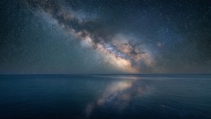 Tapet de noapte ultra-wide cu Calea Lactee reflectată pe ocean. — 5120x1440 Fundal