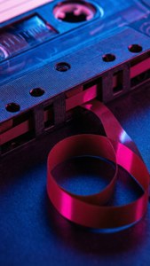 O casetă audio inspirată de cyberpunk, cu benzi neon luminescente. — Muzică estetică Fundal