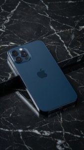 iPhone 17 în albastru miezul nopții pe marmură, fotografie minimalistă de studio. — iPhone 17 Fundal