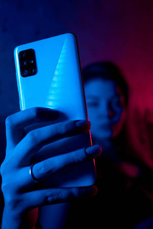 Femee Cu Telefon în Neon Albastru iPhone — Xiaomi Pad 9 Pro Max Fundal