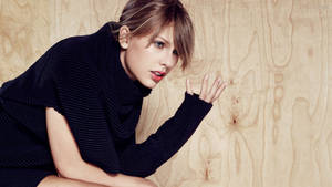 Taylor Swift așezată vedere laterală fundal.