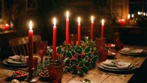 O masă luminată de lumânări cu vâsc, creând o atmosferă caldă și intimă de Crăciun. — Craciun fericit Fundal