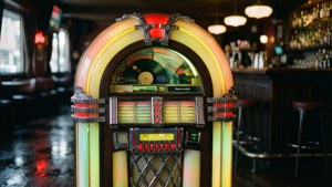 Un jukebox luminat cu neon într-un bar retro întunecat.