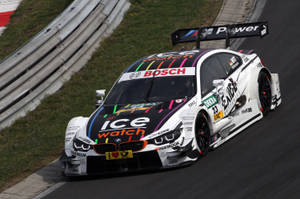 Tapet cu mașina BMW M4 DTM din 2014 pe un circuit de curse șerpuitor