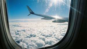 Vedere din avion cu un strat de nori dedesubt și cer albastru deasupra