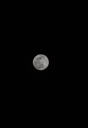 Lună plină strălucind puternic deasupra cerului negru al miezului nopții. Vedere a lunii și a satelitului.