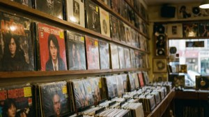 Coperți de albume expuse într-un magazin de discuri, lumină caldă. — Muzică estetică Fundal