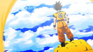Dragon Ball Z stând pe un nor galben privind planeta Namek, personajul super saiyan al popularului anime.