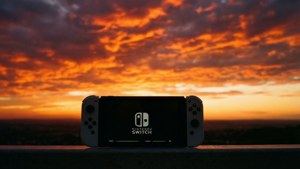 O siluetă întunecată a unui Nintendo Switch pe fundalul unui apus dramatic imagine de fundal