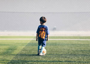 Fotografie de fundal pentru desktop cu un copil fan al fotbalului, purtând tricoul lui Lionel Messi.