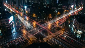 Vedere aeriană a străzilor orașului cu urme luminoase ale mașinilor noaptea. imagine de fundal