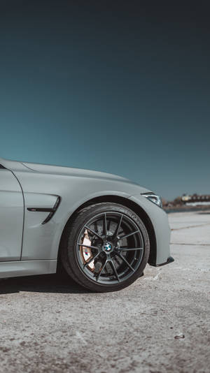 Tapet vedere laterală cu roata și sigla unei mașini BMW gri